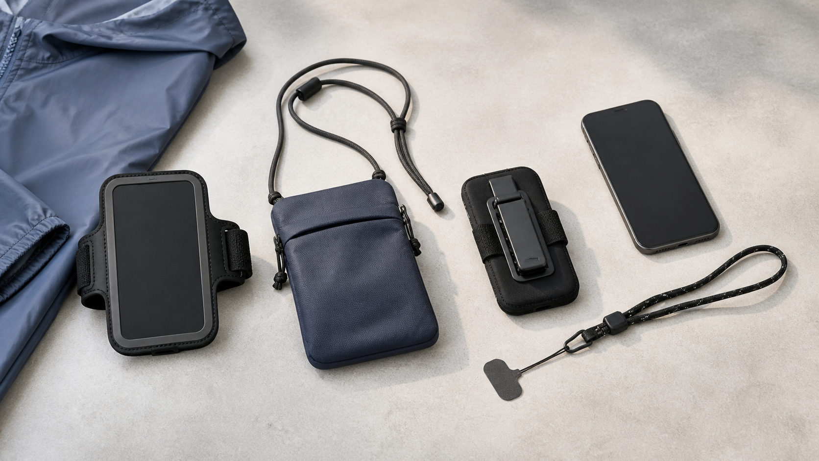 Four unbranded phone-carry options arranged on a table: an upper-arm holder, crossbody pouch, clip holster, and tether lanyard