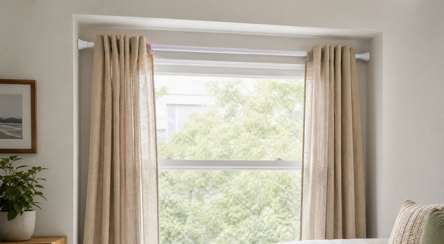 White tension-mounted no-drill curtain rod fitted inside a painted rental window recess with lightweight beige curtains