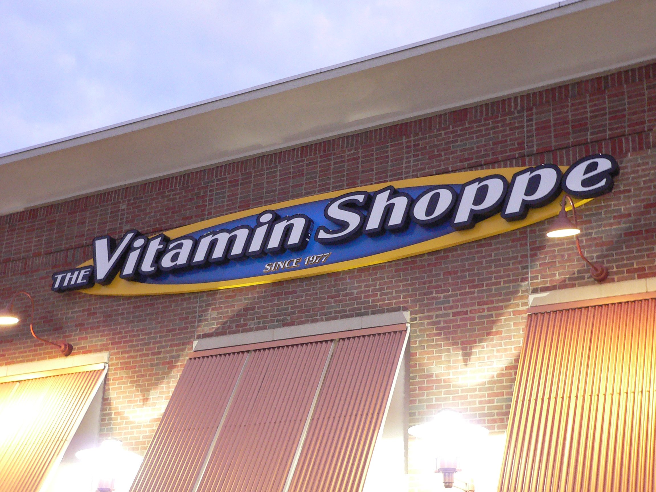 Illuminated channel letters on a storefront showing lighted faces and the surrounding wall context